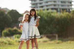 Girls are standing and posing. Happy kids are on the summer field photo
