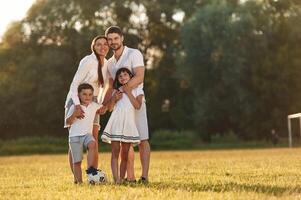 Happy family is standing together on the field photo