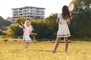 Game of badminton. Happy kids are on the summer field photo