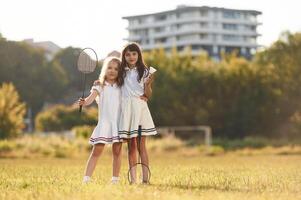 Girls are standing and posing., Happy kids are on the summer field photo