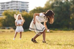 Game of badminton. Happy ,kids, are on the summer field photo