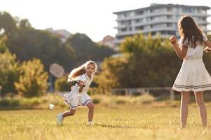 Game of badminton., Happy kids are on the summer field photo