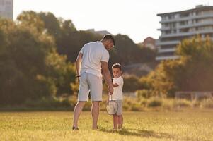 With ,badminton rackets. Father and little son are together on the summer field photo