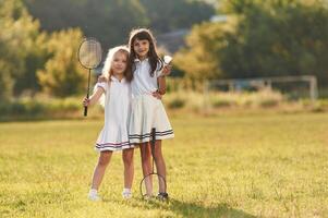 Girls ,are, standing and posing. Happy kids are on the summer field photo