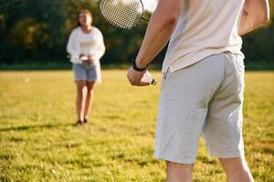 On, the summer field. Man with woman are playing badminton photo