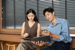 Business Collaboration and Discussion. Two professionals analyzing data on digital devices. photo