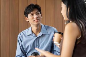 Business Conversation and Engagement. Two professionals discussing ideas with coffee in a modern workspace. photo