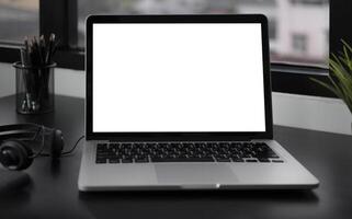 Close-up view of open blank screen laptop computer with office supplies in modern office photo