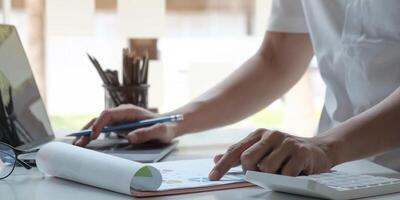 man accountant analyzing financial graph data with calculator photo