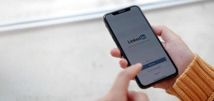 CHIANG MAI, THAILAND, APR 12, 2021 . A women holds Apple iPhone Xs with LinkedIn application on the screen.LinkedIn is a photo-sharing app for smartphones. photo