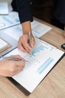 Analyzing Financial Data. Close-up of hands reviewing accounting charts and graphs in a business meeting. photo