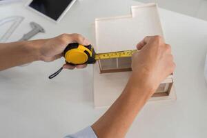 Precision in Architecture. Close-up of hands measuring model with tape. photo