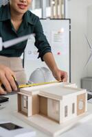 Precision in Architectural Design. Close-up of architect measuring building model for accuracy. photo