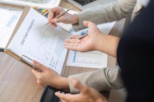 Financial Consultation and Collaboration. Business professionals discussing financial data in an office setting. photo