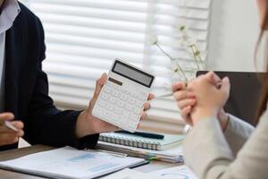 Financial Consultation with Calculator. Businessman explaining financial data to a client. photo