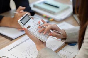 Calculator Usage in Financial Analysis. Professional woman calculating data during a meeting. photo