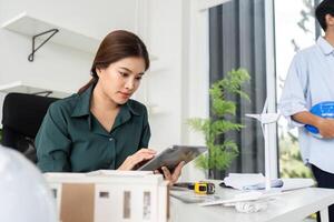 Sustainability in Architecture. Female engineer using tablet for eco-friendly project planning. photo