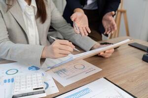 Financial Analysis and Strategy. Professionals reviewing financial documents and graphs in an office setting. photo