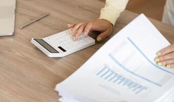 Business professional calculating finances at home with a calculator and documents photo