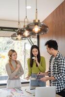 Diverse team collaborating on a design project in a modern office. photo
