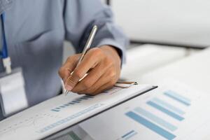 Remote Work and Digital Transformation. Professional writing on document with graphs. photo