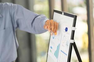 Business Presentation and Data Analysis. Professional explaining graphs on a digital board. photo