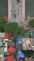 Aerial top-down view of bridge crossing canal and connecting to colorful busy street in Hanoi, Vietnam. Perfect for urban, infrastructure, and Southeast Asia travel themes. video