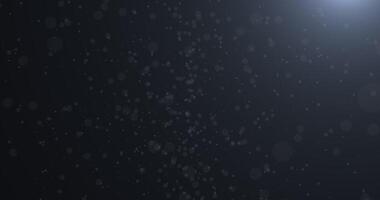 Slowly falling, swirling, and sparkling bokeh particles in white light against a dark background. Abstract snow. 43 video