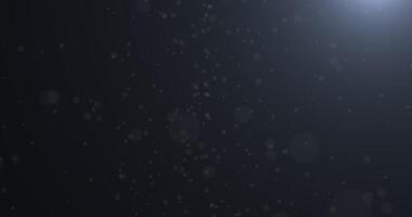 Slowly falling, swirling, and sparkling bokeh particles in white light against a dark background. Abstract snow.32 video
