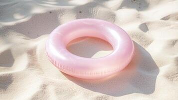 A pink inflatable ring on the sand photo
