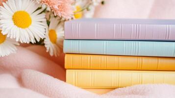 A stack of colorful books with daisies in the background photo