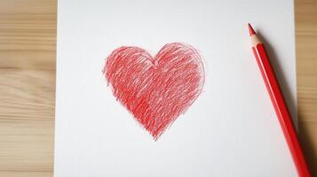 A red pencil is next to a red heart drawn on a piece of paper photo