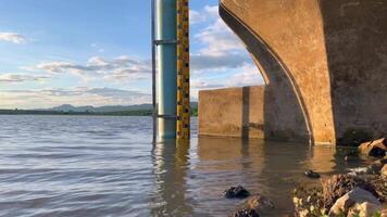 Water level at the dam, A water gauge stick in the middle of a river, showcasing accurate water level measurement with a scenic backdrop of mountains and cloudy sky video