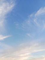 Soft white clouds drifting in a calm, clear blue sky photo