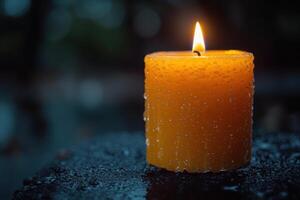 a single candle is lit on a wet surface photo