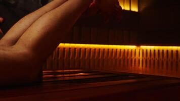 Healthy Lifestyle And Relaxation In SPA Center, Closeup View Of Male Legs On Wooden Bench In Sauna video