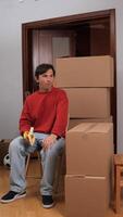 man sitting on a chair with boxes around him video