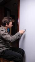 man is fixing a light switch in a room video
