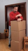 man is moving boxes in a room video