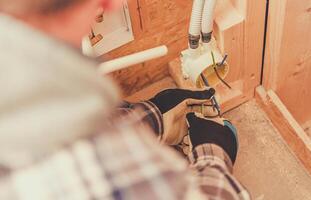 Electrician Wiring a Junction Box in a Residential Construction Project During Daylight Hours photo