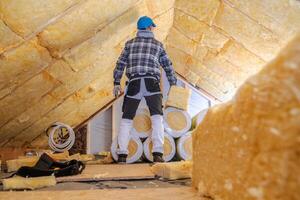 Worker Insulates Attic With Thermal Material in Residential Building During Daylight Hours for Improved Energy Efficiency photo