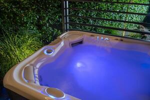 Relaxation Oasis Featuring a Illuminated Hot Tub in a Serene Garden Setting During Evening Hours photo