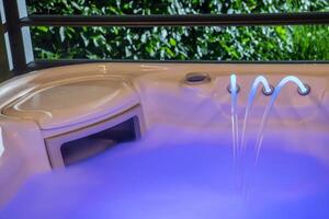 Relaxing Evening in a Modern Hot Tub Surrounded by Lush Greenery at a Home in a Tranquil Setting photo
