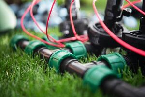 Close-up View of Newly Installed Irrigation System Components on a Turf Lawn in Sunny Weather photo