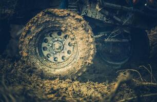 Off-road Vehicle Navigating Through Muddy Terrain During the Late Afternoon, Showcasing Powerful Tire Traction and Rugged Wheels photo