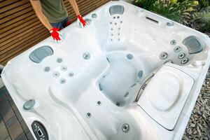 Hot Tub Installation in a Backyard Garden During Daylight With a Focus on the Heating System and Jet Features photo