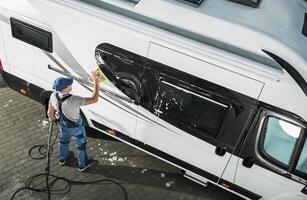 Professional Cleaning of a Recreational Vehicle Takes Place in a Driveway During Daylight Hours photo