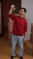 A man holding a key in his hand while standing in a room video
