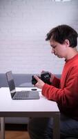 A man sitting at a table with a laptop and camera video