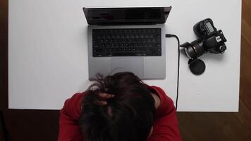 A person sitting at a desk with a laptop and camera video